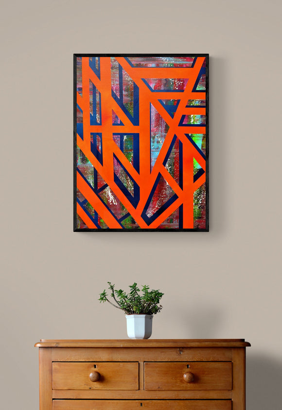 A Walk on the Beach by James Knights hung on a wall above a wooden chest of drawers. The artwork is a bold abstract consisting of an orange grid, over a blue grid with a random coloured background created using a squeegee.